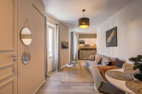 Modernes Luxusapartment in Cannes mit offener Wohnfläche, Sofa, Kochnische und eleganter Einrichtung.