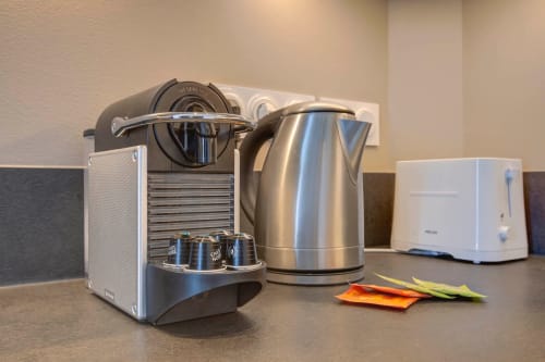 Moderne Küchengeräte in Luxuswohnung in Cannes: Espressomaschine, Edelstahlwasserkocher und Toaster auf der Arbeitsplatte