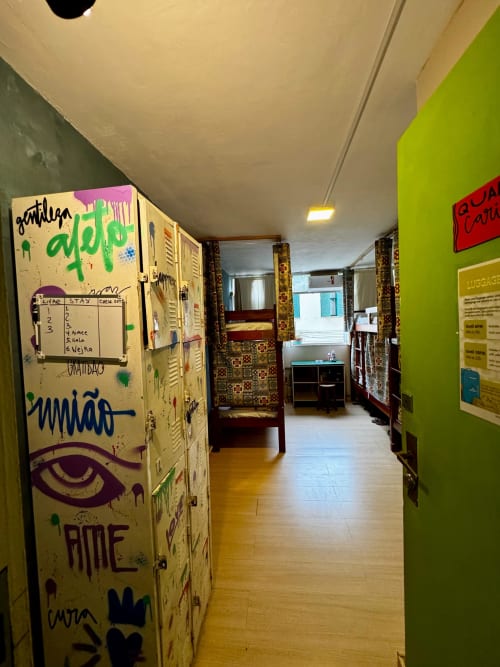 Corredor colorido do Hostel New Ipanema Rio com armários grafitados e paredes vibrantes