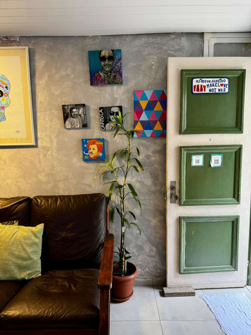 Área de convivência do Hostel New Ipanema Rio de Janeiro com sofá de couro, arte colorida, porta verde e planta em vaso