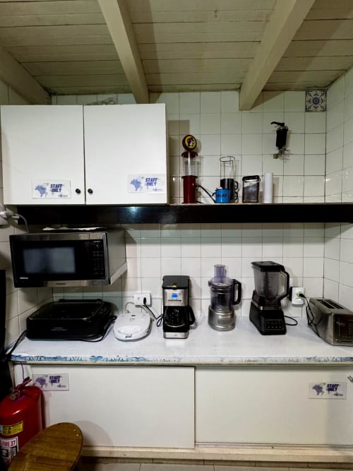 Cozinha de funcionários no Hostel New Ipanema Rio de Janeiro com eletrodomésticos, micro-ondas, liquidificador e cafeteira