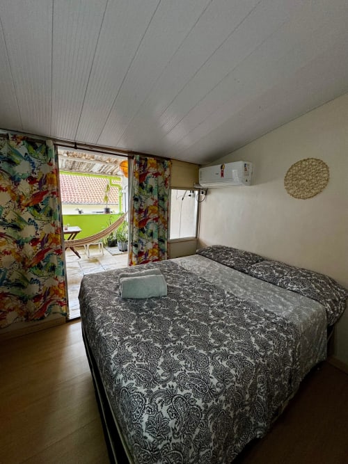 Quarto privativo na Pousada New Ipanema com duas camas, vista para o jardim, ar-condicionado e acesso ao pátio externo no Rio de Janeiro
