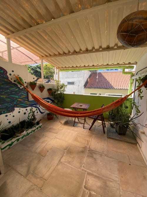Pátio coberto com rede e plantas no Hostel New Ipanema, quarto com vista para o jardim no Rio de Janeiro
