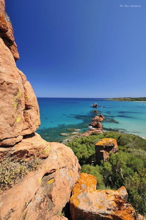 Scogliere di roccia rossa che dominano le acque turchesi del Mediterraneo al Resort Baia Cea, Bari Sardo, Sardegna
