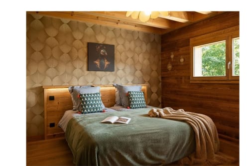 Chambre cosy du chalet en bois au Domaine des Fleurs, Gérardmer avec lit queen-size, papier peint à motifs et vue sur les montagnes.