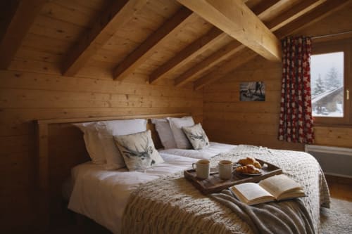 Chambre chaleureuse en bois du Domaine des Fleurs à Gérardmer, avec vue sur les montagnes et décoration alpine rustique