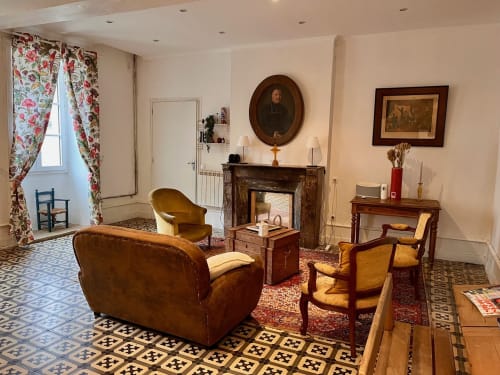 Élégant salon du Château de Moulins avec fauteuils en cuir, cheminée et décoration traditionnelle