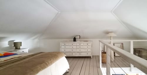 Chambre mansardée lumineuse aux Balcons D'Oyster Pond avec lit en bois, commode blanche et plafonds inclinés à Saint-Martin