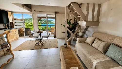 Appartement-bungalow aux Balcons d'Oyster Pond, Saint-Martin avec vue mer, canapé beige, cuisine, salle à manger et accès waterfront
