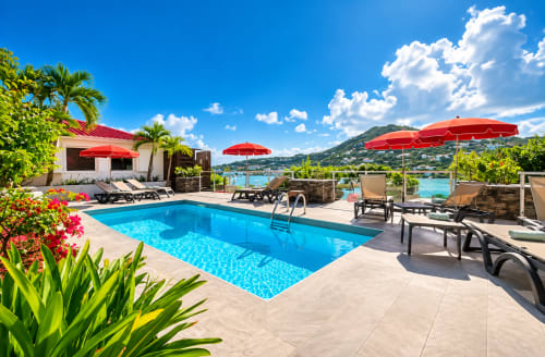 Luxe au bord de la piscine aux Balcons D'Oyster Pond, Saint-Martin. Piscine bleu cristal, parasols rouges, chaises longues
