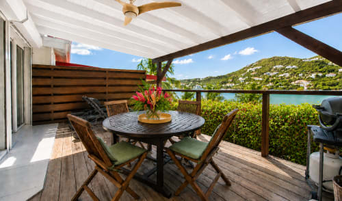Terrasse de bungalow face à l'océan aux Balcons d'Oyster Pond, Saint-Martin avec table à manger, vue mer et paysage tropical