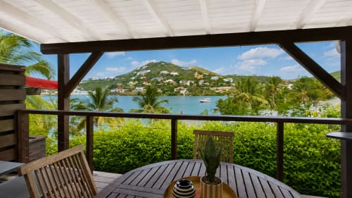 Terrasse couverte avec vue sur mer aux Balcons d'Oyster Pond, Saint-Martin, dominant l'Oyster Pond avec palmiers