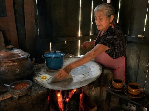 Mujer preparando comida tradicional mexicana en comal de piedra en el hotel Sento SanMa de San Mateo Rio Hondo
