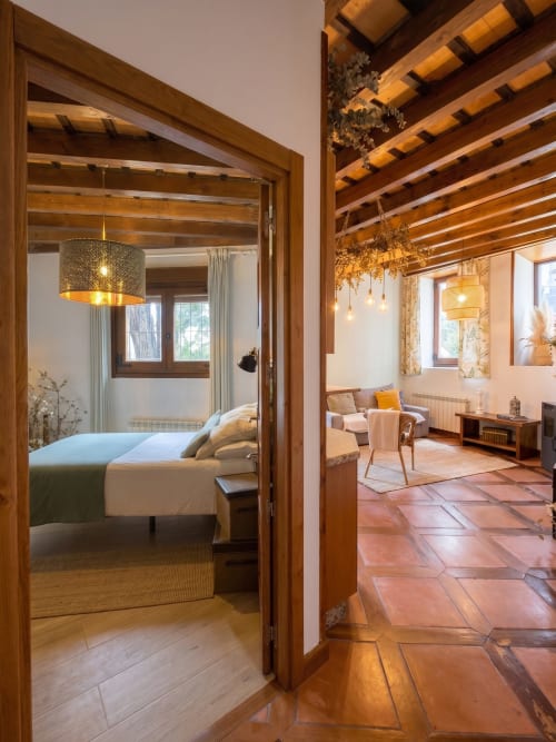 Apartamento Cerezo en El Aserradero, La Alberca, con vigas de madera, vista del dormitorio y sala con baldosas de barro