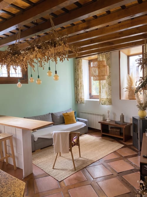 Apartamento Cerezo en El Aserradero La Alberca con paredes menta, vigas de madera, lámparas colgantes y vista al jardín