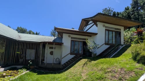 Cottage Fare Tihi Moana à Tumaraa : murs blancs, terrasse en bois, jardins luxuriants et vue mer en Polynésie française