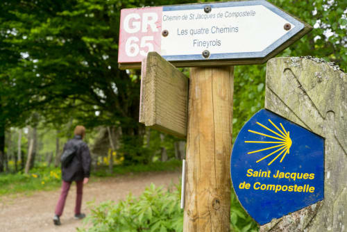 Panneau du sentier de randonnée GR65 pour le Chemin de Saint-Jacques-de-Compostelle près de l'Hôtel du pont d'Estaing à Estaing, France
