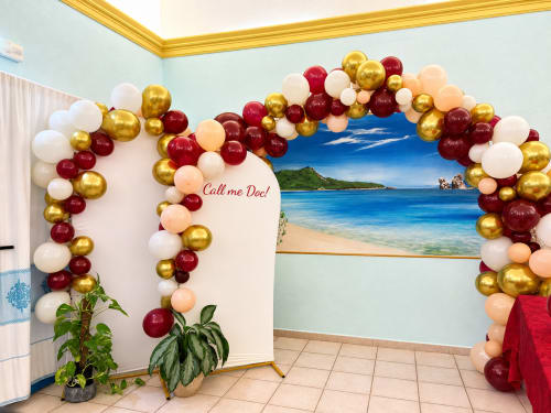 Fondale fotografico di spiaggia tropicale decorato con palloncini dorati, bordeaux e bianchi al Resort Baia Cea di Bari Sardo