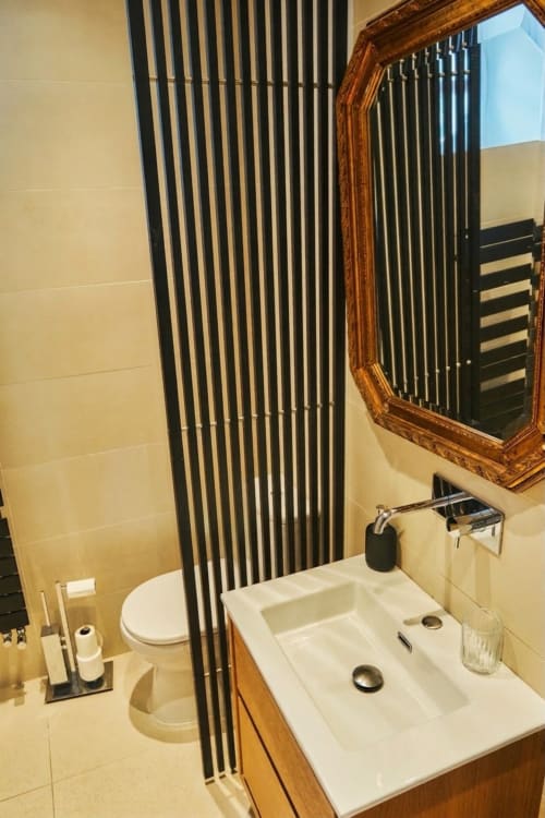 Baño moderno de la Habitación 1 en Château de Villa Raspail B&B, Ivry-sur-Seine, con doble lavabo, espejo y revestimiento negro vertical