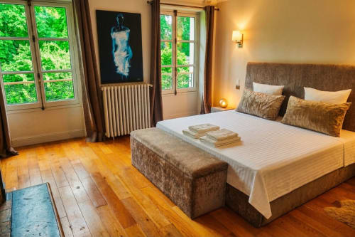 Chambre élégante à la Villa Raspail avec lit queen, parquet, vue sur le jardin par portes-fenêtres et équipements modernes