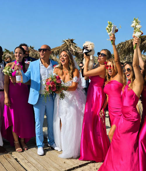 Celebrazione di matrimonio sulla spiaggia al Resort Baia Cea con sposa, sposo e damigelle in abiti rosa