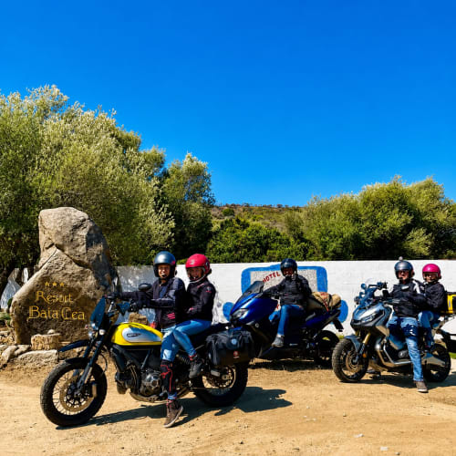 Gruppo di motociclisti con caschi presso Resort Baia Cea, Bari Sardo, scenario collinare soleggiato
