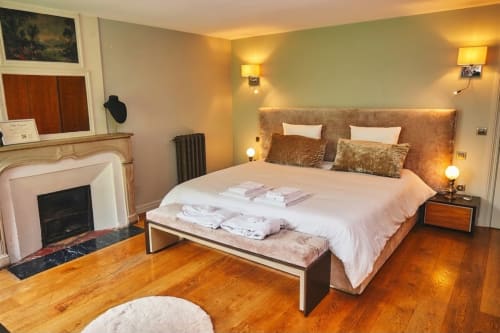 Chambre élégante à la Villa Raspail B&B avec cheminée, tête de lit capitonnée, parquets et éclairage chaleureux