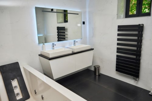 Baño moderno en Villa Raspail en Ivry-sur-Seine con dos lavabos, espejo iluminado y toallero negro