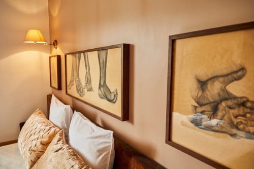 Dormitorio elegante en Villa Raspail con arte anatómico en la pared, almohadas blancas, iluminación cálida y muebles de madera