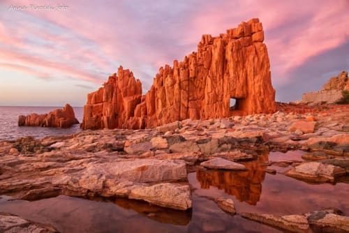 Suggestive formazioni rocciose rosse al tramonto sulla spiaggia di Bari Sardo, Sardegna, vicino al Resort Baia Cea