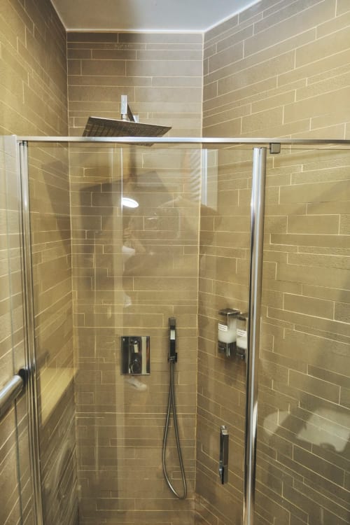 Moderno baño con ducha tropical y grifería negra en el apartamento Villa Raspail en Ivry-sur-Seine, Francia