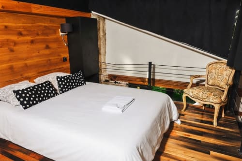 Dormitorio moderno en Villa Raspail con detalles de madera, cama blanca, almohadas de lunares y balcón con vistas al jardín en Ivry-sur-Seine