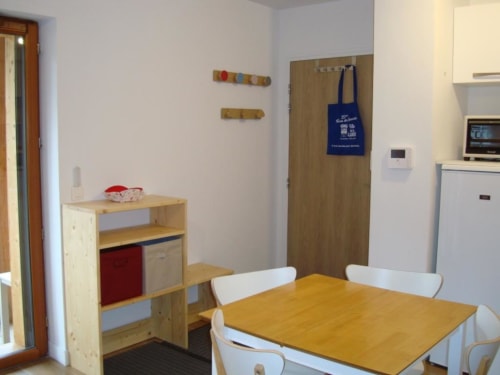 Cuisine-salle à manger moderne dans l'appartement de Vars avec table en bois, rangements et équipements