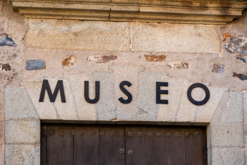 Cartel de entrada al Museo en fachada de piedra en Apartamentos La Machacona, España