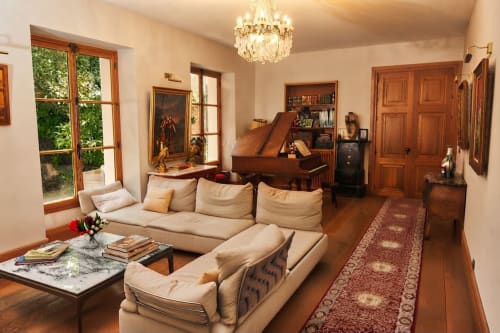 Élégant séjour de la Villa Raspail B&B à Ivry-sur-Seine avec canapé crème, grand piano, lustre en cristal et parquet
