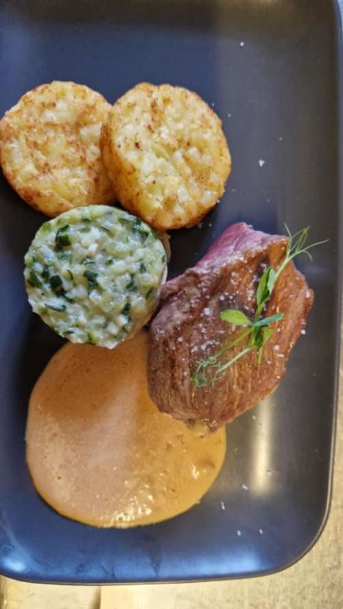 Assiette de steak gastronomique au Perroquet Bleu avec beurre aux herbes, galettes de pommes croustillantes et sauce béarnaise