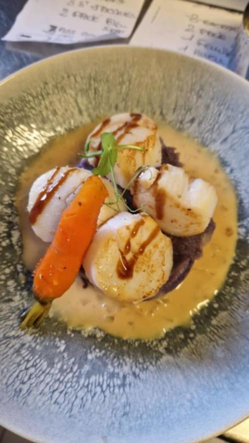 Pétoncles poêlés, sauce carotte-crème et microherbes au Perroquet Bleu, France