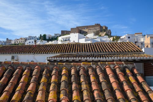 Tejados de barro de Hotel Boutique Alcazaba con ruinas de castillo morisco y casarios blancos en Salobreña, Granada