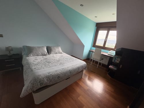 Habitación moderna con detalles en turquesa, suelos de madera y vistas al mar en el hotel boutique Casa Aida Foz, Vilaronte, Lugo