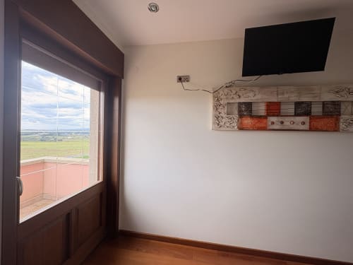 Habitación doble Casa Aida Foz con TV, vistas al campo a través de puertas francesas y decoración mural