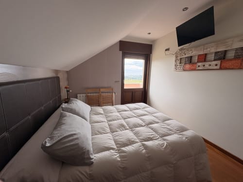 Acogedora habitación doble en Casa Aida con vistas al mar, televisión y muebles de madera en Lugo