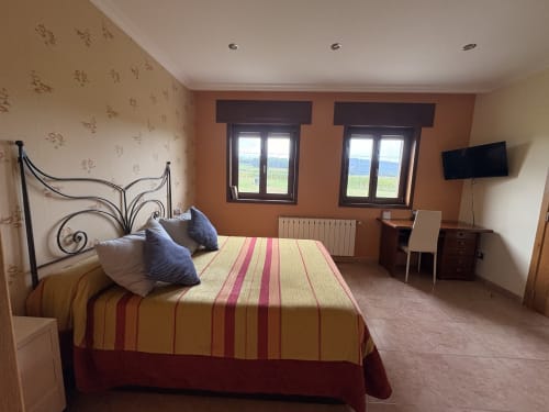 Espacioso dormitorio doble en Casa Aida con vistas al mar, cama de hierro forjado, ropa de cama a rayas y comodidades modernas en Vilaronte