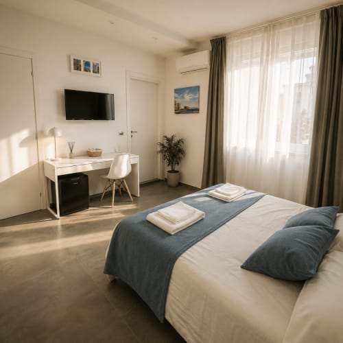 Camera moderna presso Soave Rooms B&B Napoli con letto matrimoniale, scrivania, TV e vista sulla città