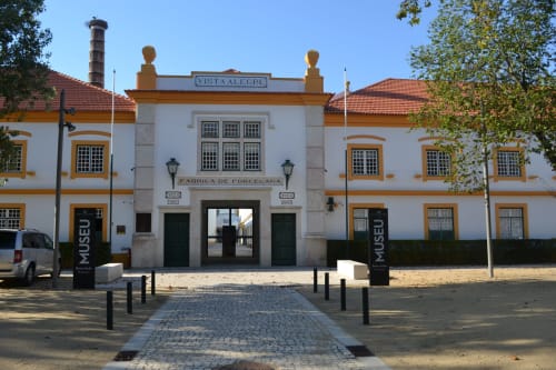 Entrada do museu da fábrica de porcelana Vista Alegre em Aveiro, Portugal com arquitetura colonial branca e amarela
