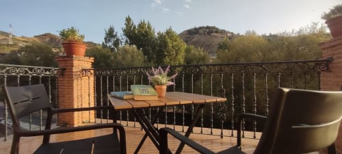 Zona de estar en terraza de Hospedería Puerta a los Cahorros en Monachil con vistas a las montañas