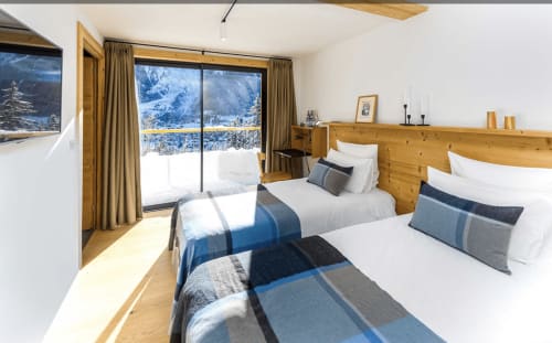 Chambre deluxe au Chalet Mont-Blanc avec lits jumeaux, vue montagne, mobilier en bois et balcon enneigé aux Houches