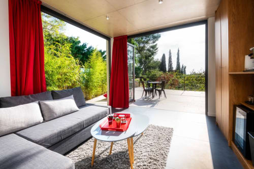 Chambre Canaille at Villa Annette, Cassis: Modern living room with gray sofa, red curtains, sea view terrace