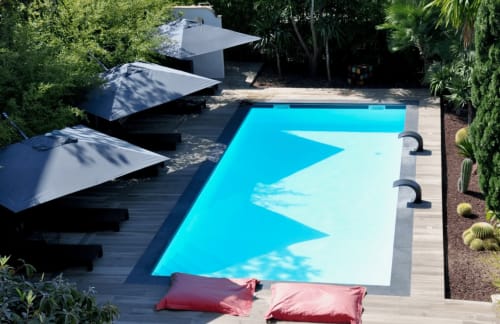 Modern pool at Villa Annette in Cassis with loungers, white umbrellas, and sea view from Suite Junior Corton