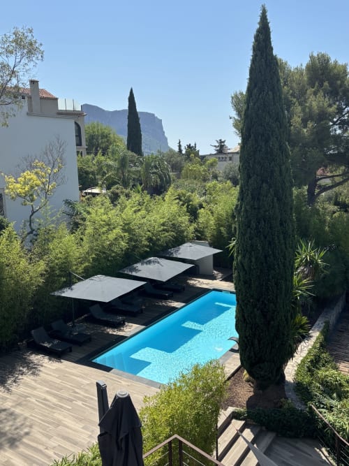 Villa Annette pool terrace in Cassis with loungers, cypress trees, and mountain backdrop
