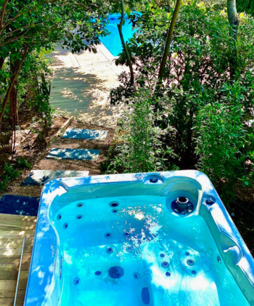 Turquoise jacuzzi overlooking Mediterranean Sea in Cassis, Villa Annette spa room with lush greenery